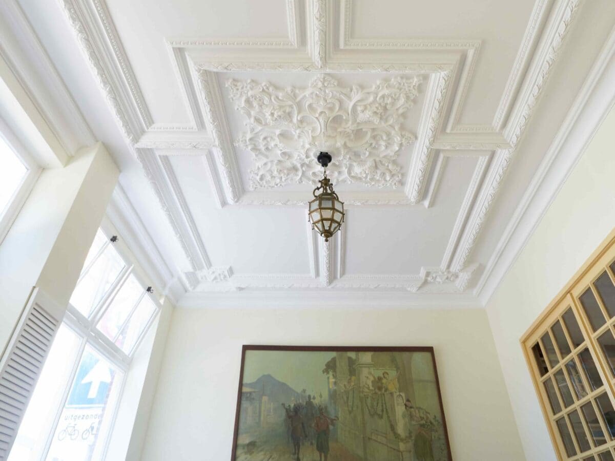 Sierlijk stucplafond met luchter in de praktijk van Vita